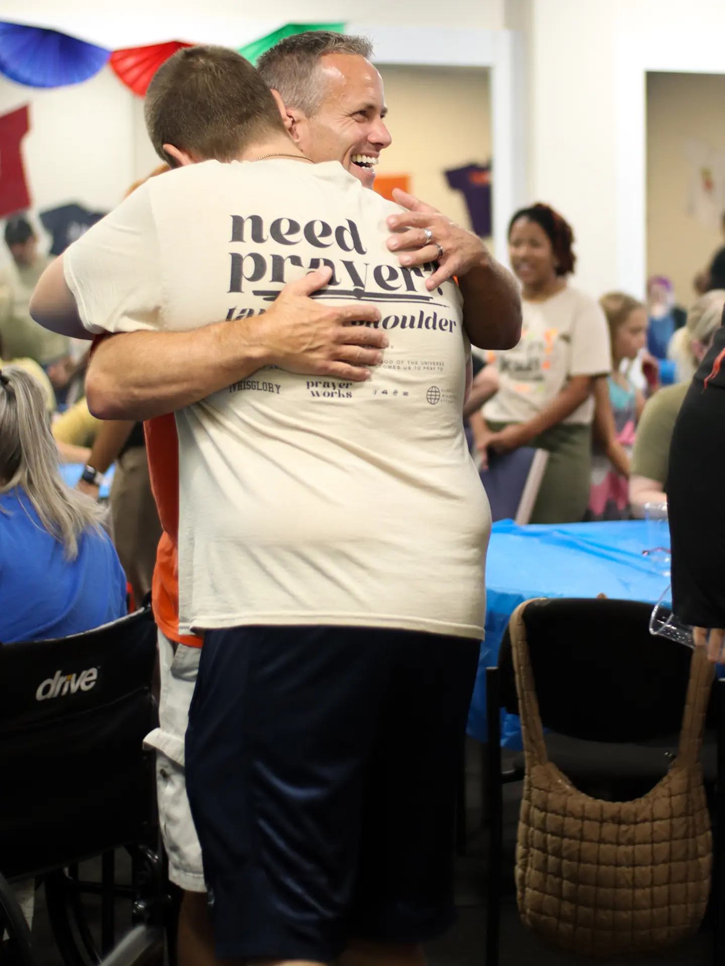 Pastor Jim of Matheteuo Ministries embracing a member of his congregation at a church celebration