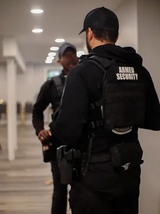 AegisPoint Security Services armed officer standing post in an office hallway