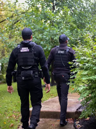 Two AegisPoint Security Services officers walking the perimeter of a property