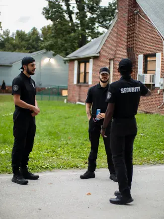 AegisPoint Security Services team talking through a detail on a front lawn